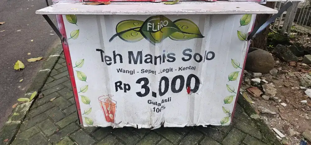 Wanita jaga gerobak teh dan makanan